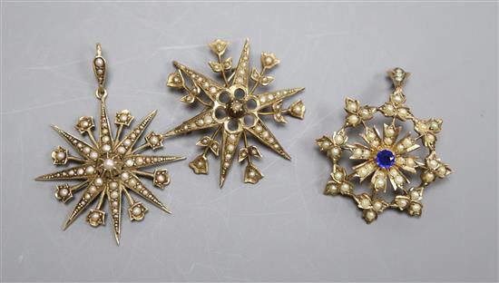 Three assorted Edwardian yellow metal and seed pearl set starburst pendants or brooches, including two stamped 9ct, largest 32mm.